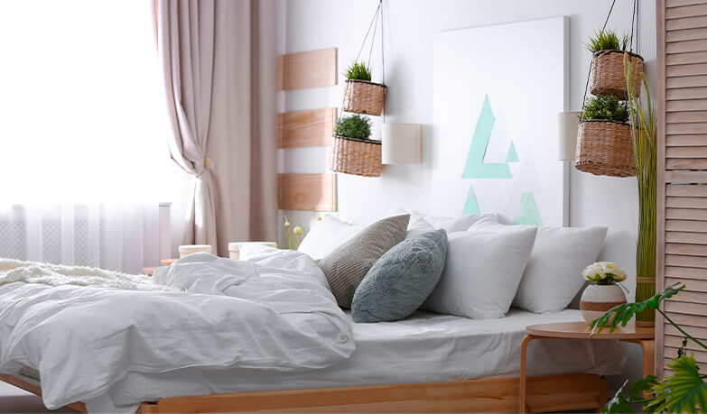 Neutral coloured bedroom with white bedding and wooden decorative elements 